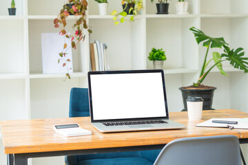 Side view of contemporary workplace with laptop computer, notebook, coffee cup and stationery on wooden table. clipping path.