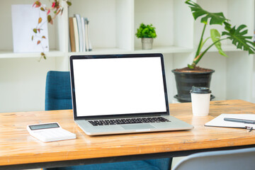 Side view of contemporary workplace with laptop computer, notebook, coffee cup and stationery on wooden table. clipping path.