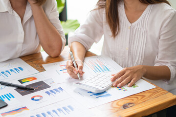 Smiling middle-aged female employee talk brainstorm with female colleague at office briefing in boardroom, happy diverse coworkers have fun laugh cooperating discussing ideas at meeting