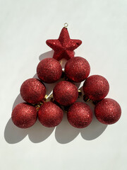 Christmas  decorations in the shape of the Christmas tree on the white table. Christmas red balls...