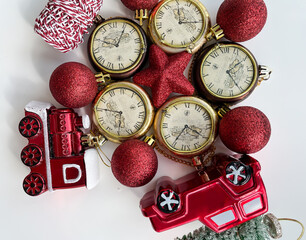 Top view of the set of Christmas decorations on the table: old clocks, red toy train, red Christmas tree balls, star, ribbon. Preparation for Christmas. Christmas decorations background.