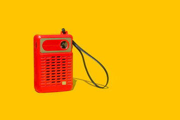 Radio retro roja sobre un fondo amarillo liso y aislado. Vista de frente. Copy space