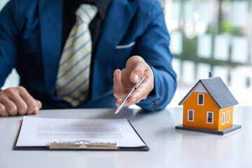 The real estate agent is explaining the contract to rent or buy, inspect the sample home and Business contract, lease, purchase, mortgage, loan or home insurance documents