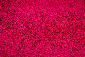 The texture of a red cloth with a pile, a bath towel for a shower.
