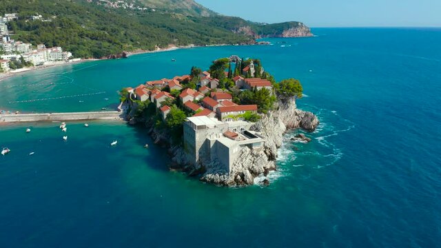 Famous Sveti Stefan island in Budva during a beautiful summer day, Montenegro. Aerial drone view 4K