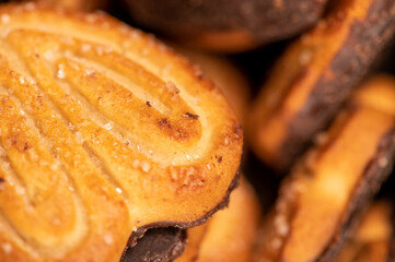 Curly cookies covered with chocolate icing, background image, close-up, selective focus.