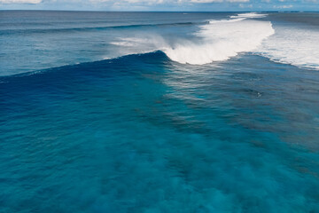 Blue barrel waves in tropical sea. Aerial view of surfing waves
