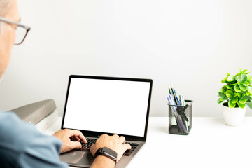 Close-up of male hands, laptop with a white blank screen on a table in office. Working concept using a notebook, internet. Copy space on left for design or text, Closeup, Gray, and blurred background