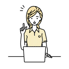 デスクで座ってPCを開いて何かひらめいたポロシャツの女性