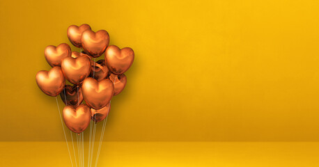 Copper heart shape balloons bunch on a yellow wall background. Horizontal banner.