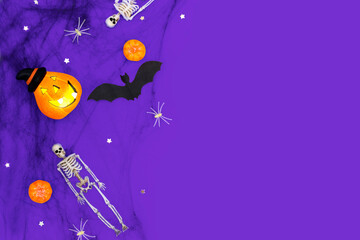 Happy Halloween party decorations. Festival dark purple banner background with pumpkins, spiderwebs, skeletons, bats and spiders. Invitation, greeting card layout, copy space.