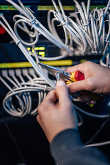 Working on setting up the ethernet network. Using long-nose pliers.