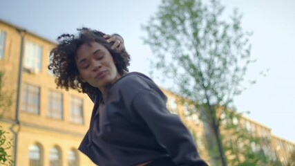 Confident black woman dancer dancing outdoors, street dance culture, slow motion