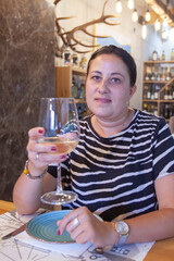 Portrait of happy woman drinking wine in restaurant