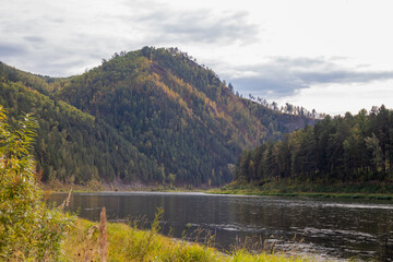 Autumn landscape. A winding river flows out of a mountainous area.