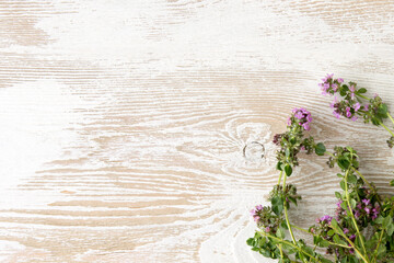 flat lay of sprigs of blooming thyme on wooden background, space for text