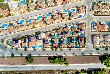Pinar de Campoverde residential district view from above. Drone point of view luxury summer villas with swimming pools townscape rooftops at sunny summer day. Costa Blanca, Province of Alicante, Spain