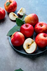 Fresh red apples with green leaves on a black background. Fruits. Top view, copy space.