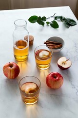 Fresh red apples and apple juice in glasses and bottle on a light background. Fruits and drinks. Top view, copy space.