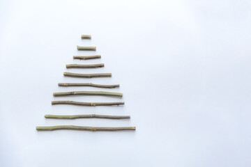 A simple composition of dry sticks in the shape of a triangle, arrows on a white background. space...