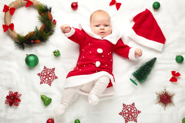 Baby Dressed up for First Christmas with christmas decoration on white background.