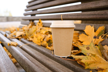 Craft paper cup with paper lid in the texture of autumn leaves. Ecology and nature. Disposable paper cup close up. Eco material. Glass for hot drinks. Empty space for text, mock up
