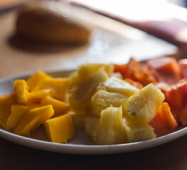 Plate of sliced fruit on table with blurry and bright background