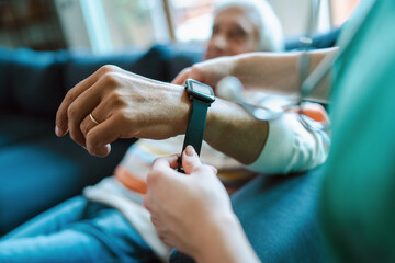 Smartwatch for assisted living. A woman from the medical health system wears a smartwatch for...