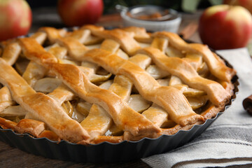 Delicious traditional apple pie on wooden table, closeup