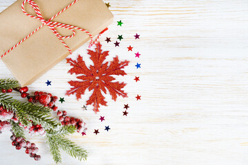 Decorated Christmas tree and New Year decorations, gift box, garland and clock on white wooden background with copy space. Top view, flatlay.