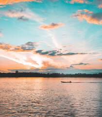 Boat meanders forward during the most surreal sunset on the river