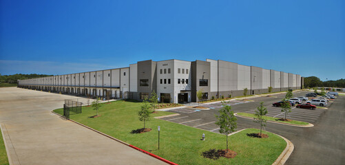 Fototapeta na wymiar Modern gray industrial distribution warehouse and parking lot