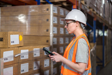 Store worker using a barcode scanner for stock counting in warehouse. 