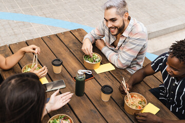 Diverse friends eating take away food outdoor - Real people, millennial lifestyle - Focus on queer...