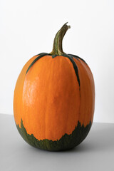 Pumpkin on a grey and white background. Yellow and green pumpkin. Autumn concept, thanksgiving day