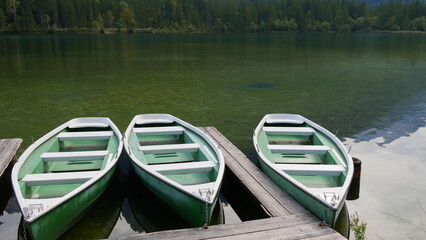 Drei Ruderboote warten am Bootssteg auf Gäste
