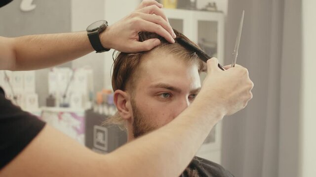 Giovane ragazzo si taglia i capelli dal parrucchiere