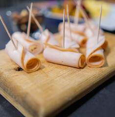 Fresh turkey ham rolls on a wooden cutting board