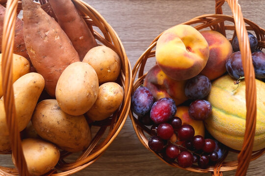 Two vintage baskets filled with various fruti and vegetable on wooden table. Top view.