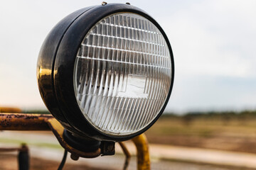 Powerful halogen headlight on a road construction vehicle. Work at night. Lighting of ongoing...