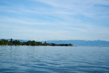 Der Bodensee mit Segelbooten und Bergen im Hintergrund