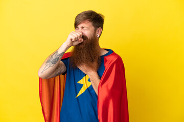 Redhead Super Hero man isolated on yellow background is suffering with cough and feeling bad