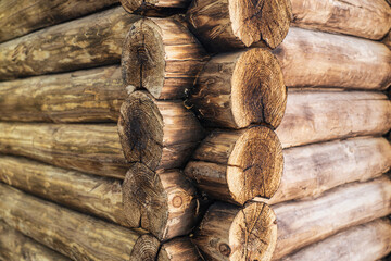 The corner of a house made of wooden logs, the corner joint of a chopped log house. Horizontal photo