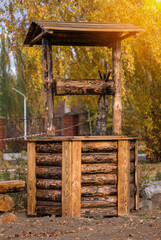 A wooden well made of burnt logs as a design element of a public park