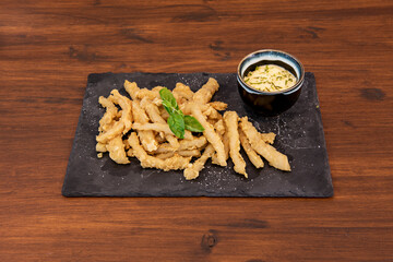 typical Spanish tapa of squid rabas battered with flour and egg, fried in olive oil and served with aioli sauce