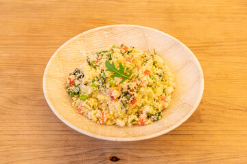 Wooden simile plate with recipe for vegetable tabbouleh with olive oil on wooden table