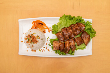 suckling pig kawali, a Filipino dish made from crispy fried pork belly garnished with white rice with vegetables