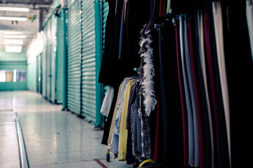 Closed curtains in a local market in downtown Mexico. Just one store open. Clothes in display 