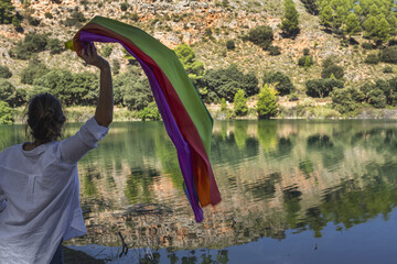 Middle-aged lesbian woman holding the Gay Rainbow Flag