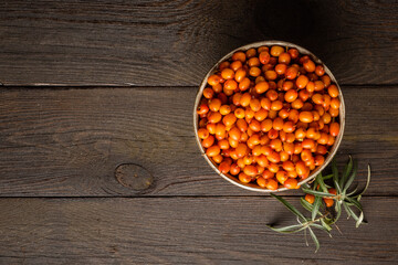 Sea buckthorn. Fresh ripe organic berries on wooden background. Super food ingredients vegetarian healthy concept